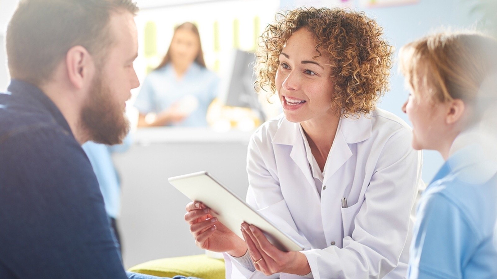 Doctor and nurse discussing over digital tablet in ward at hospital