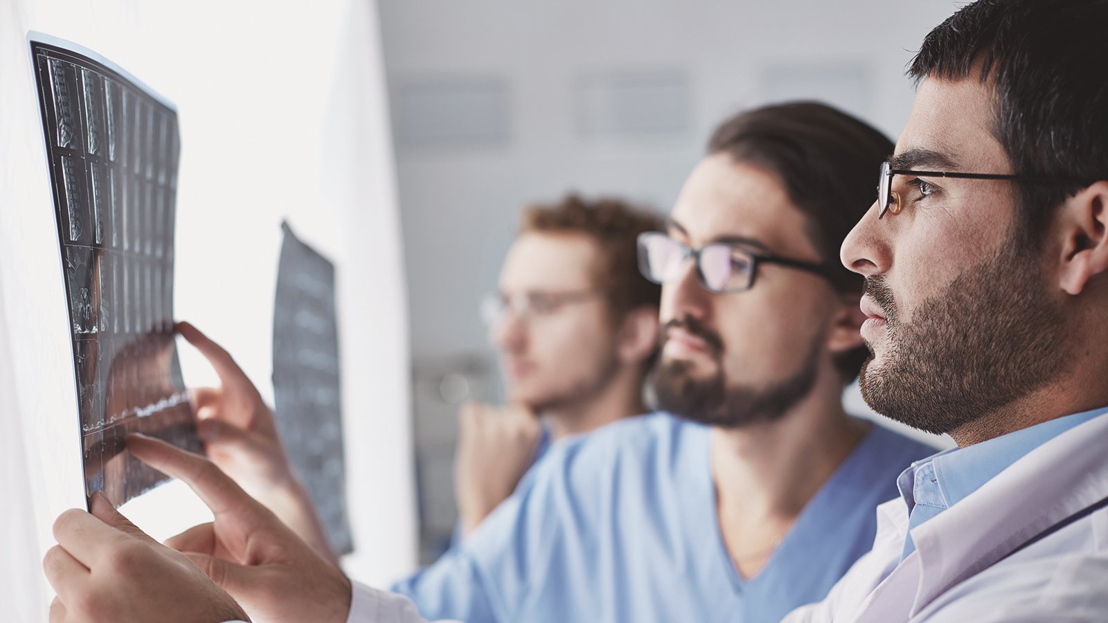 Healthcare, medical: Group of multi-ethnic doctors discuss and looking x-ray in a clinic or hospital