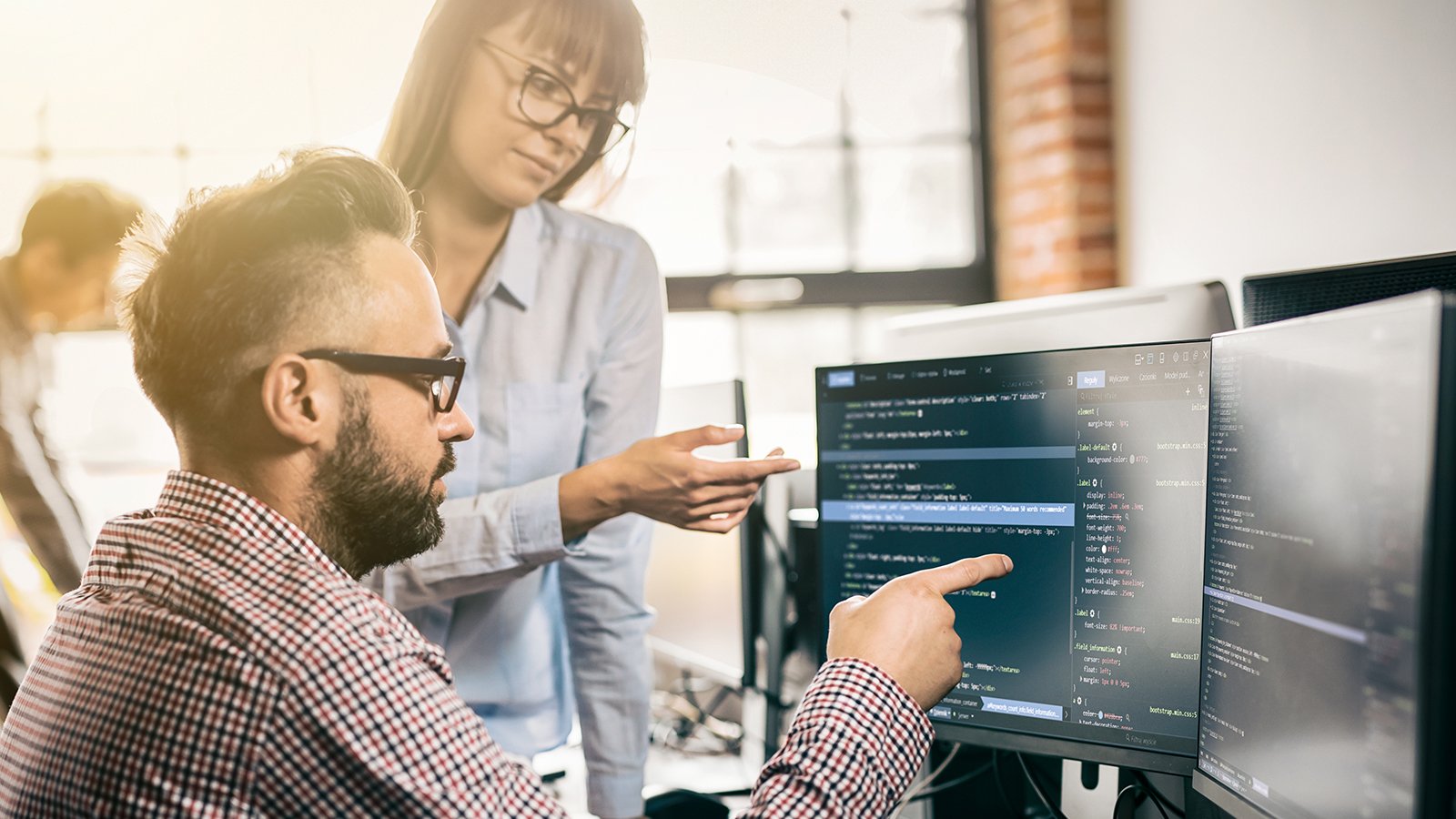 Man and woman discussing around coding