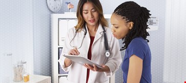 Doctor is discussing with patient with smile