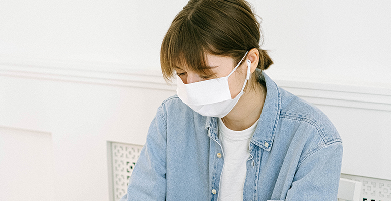 Young business woman wearing face mask working on computer