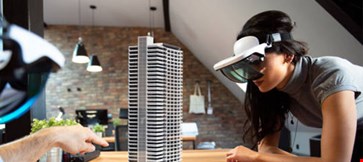 Two people working on virtual 3d building by using AR glasses.