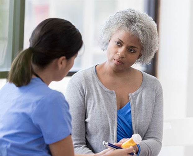 Pharmacist discussing medication with senior customer