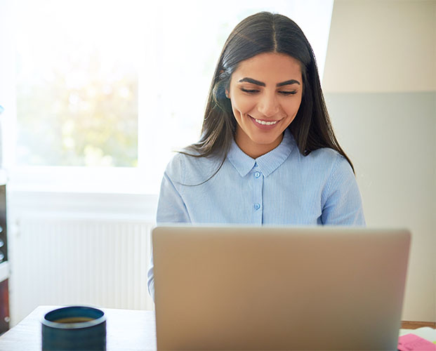 Young teenage female learning online on her laptop at home