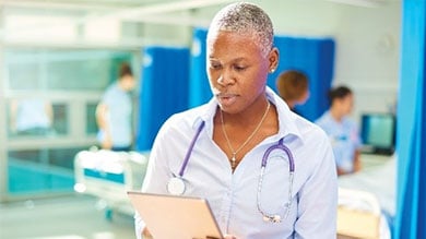 Female health worker working on tablet grid