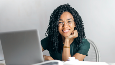 Teenage girl at laptop computer smiling