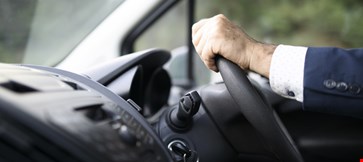Car driver hands holding steering wheel