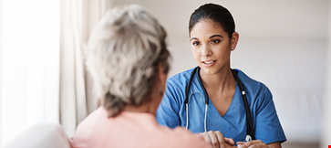 Attractive young nurse holding a senior womans hands in comfort