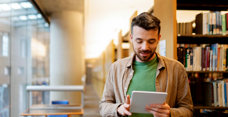 Bearded middle aged man is using digital tablet