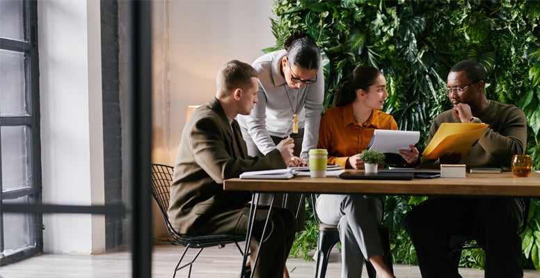 Diverse group of young adult and middle aged men and women collaborating at table