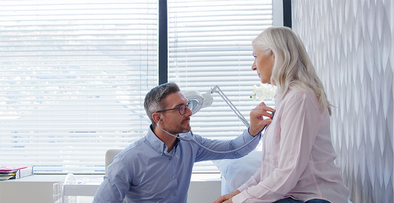 Smiling Nurse in Hospital Scrubs Using Digital Tablet