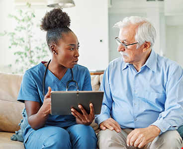 Doctor nurse caregiver showing tablet screen