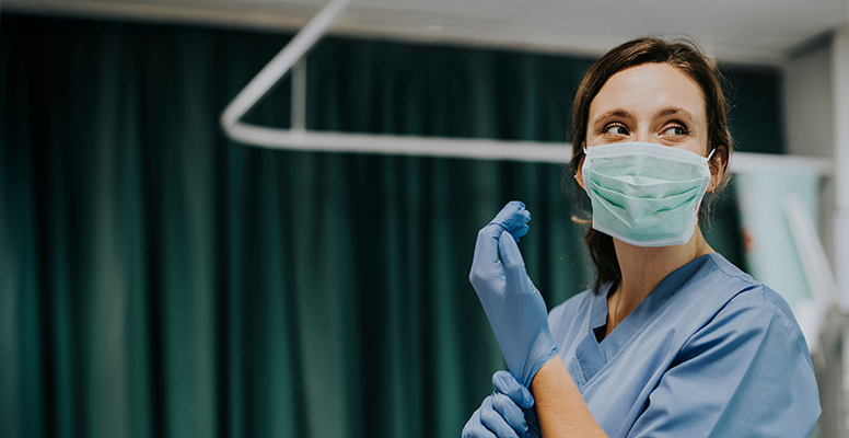female-nurse-mask-putting-on-gloves