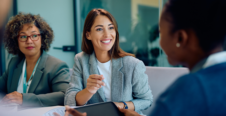 Happy female entrepreneur communicating with coworkers