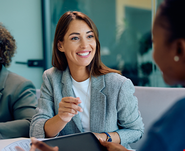 Happy female entrepreneur communicating with coworkers