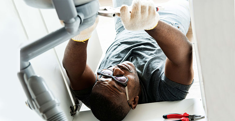 Plumber man fixing kitchen sink