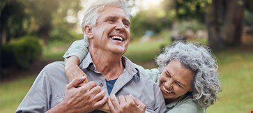 Senior couple hugging in park, garden and retirement to relax