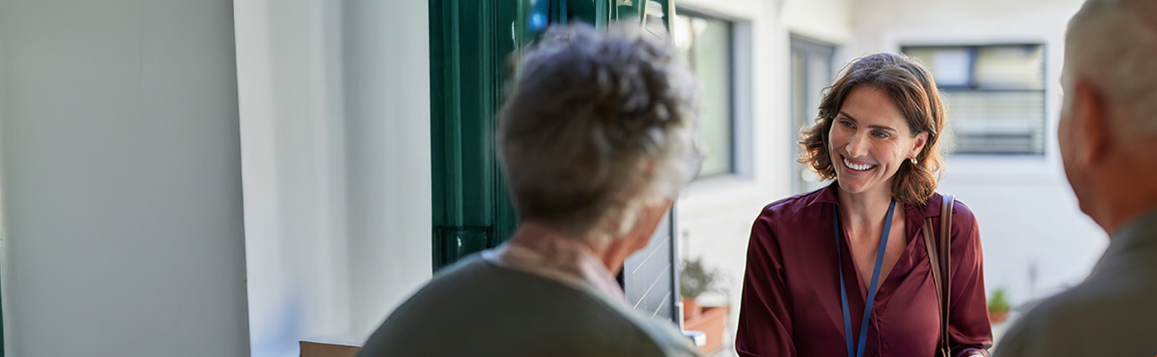 Smiling community worker talking with two residents