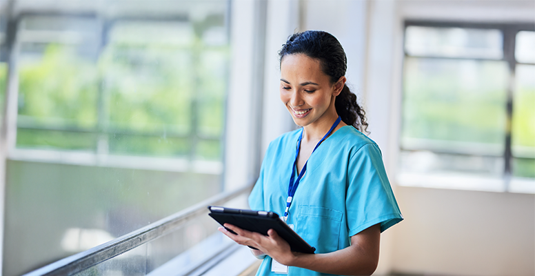 Smiling Nurse in Hospital Scrubs Using Digital Tablet in Modern Medical Facility