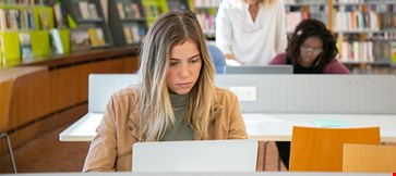 Woman studying in the library on the laptop
