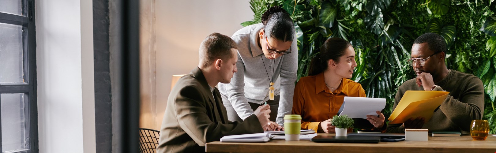 Diverse group of young adult and middle aged men and women collaborating at table