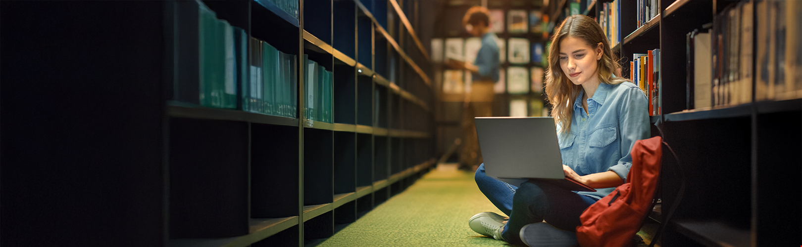 Young girl with laptop in library