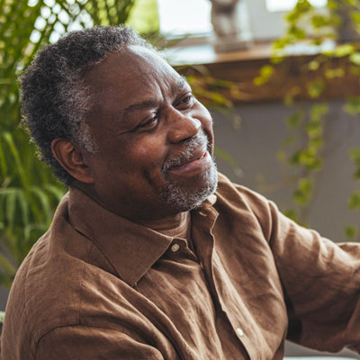Female healthcare worker holding hands of senior man at care home