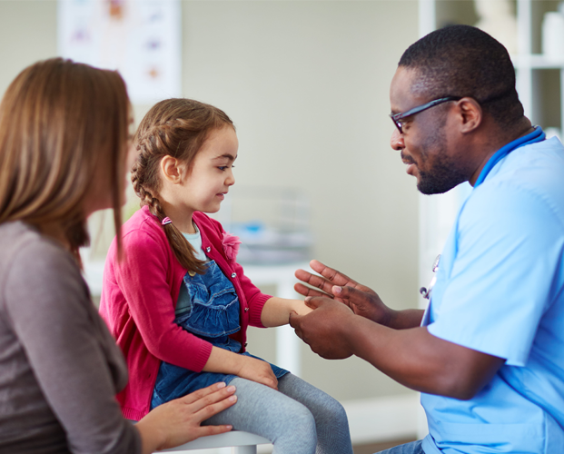 Male doctor discuss with child patient