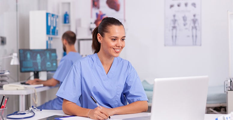 female doctor in uniform is working behind laptop in hospital