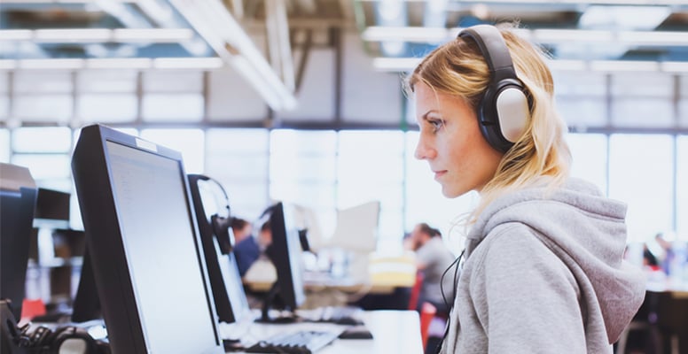 Adult education student in headphones working on computer