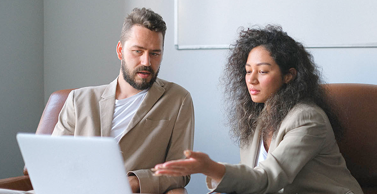 Business colleagues using laptop at meeting