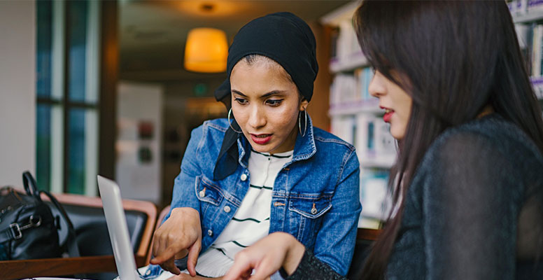 Two business women using notebook and Discussion of the important contract at office