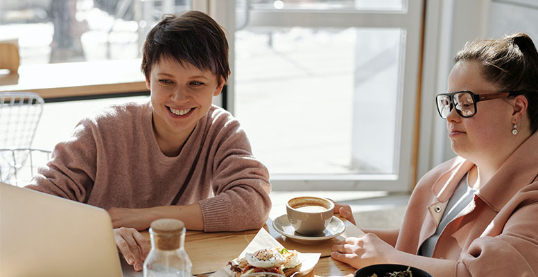 Two happy business woman working on a laptop