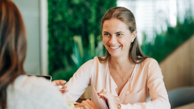 Young happy woman smiling and talking with colleague