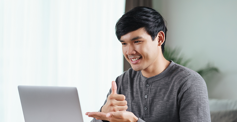 Young Asian man deaf disabled using laptop