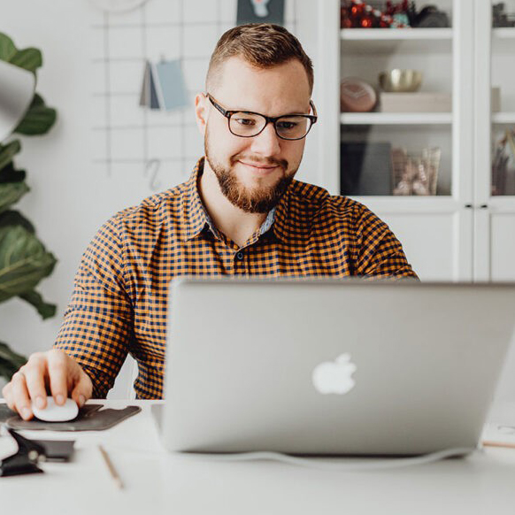 Man working on a laptop with a smiling face