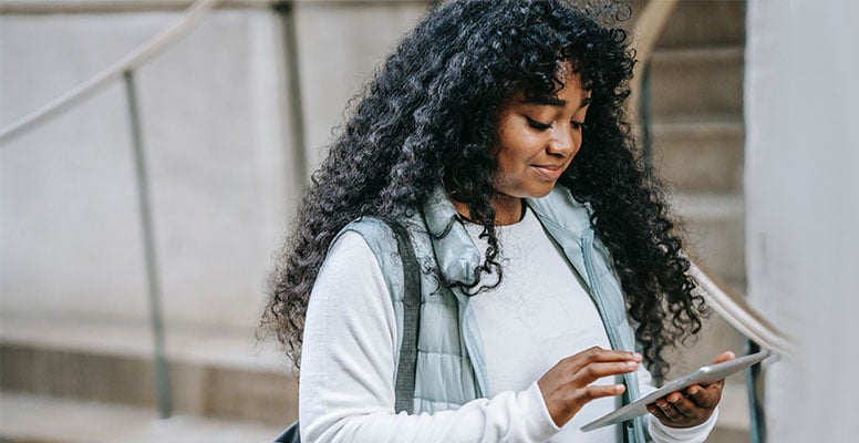 A curly haired young girl managing bill using tablet